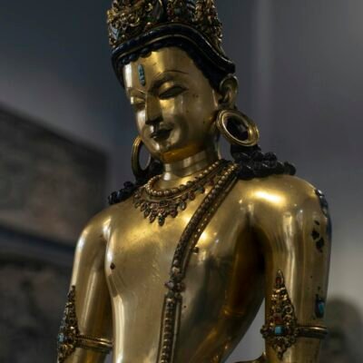 A gold statue of buddha in a museum